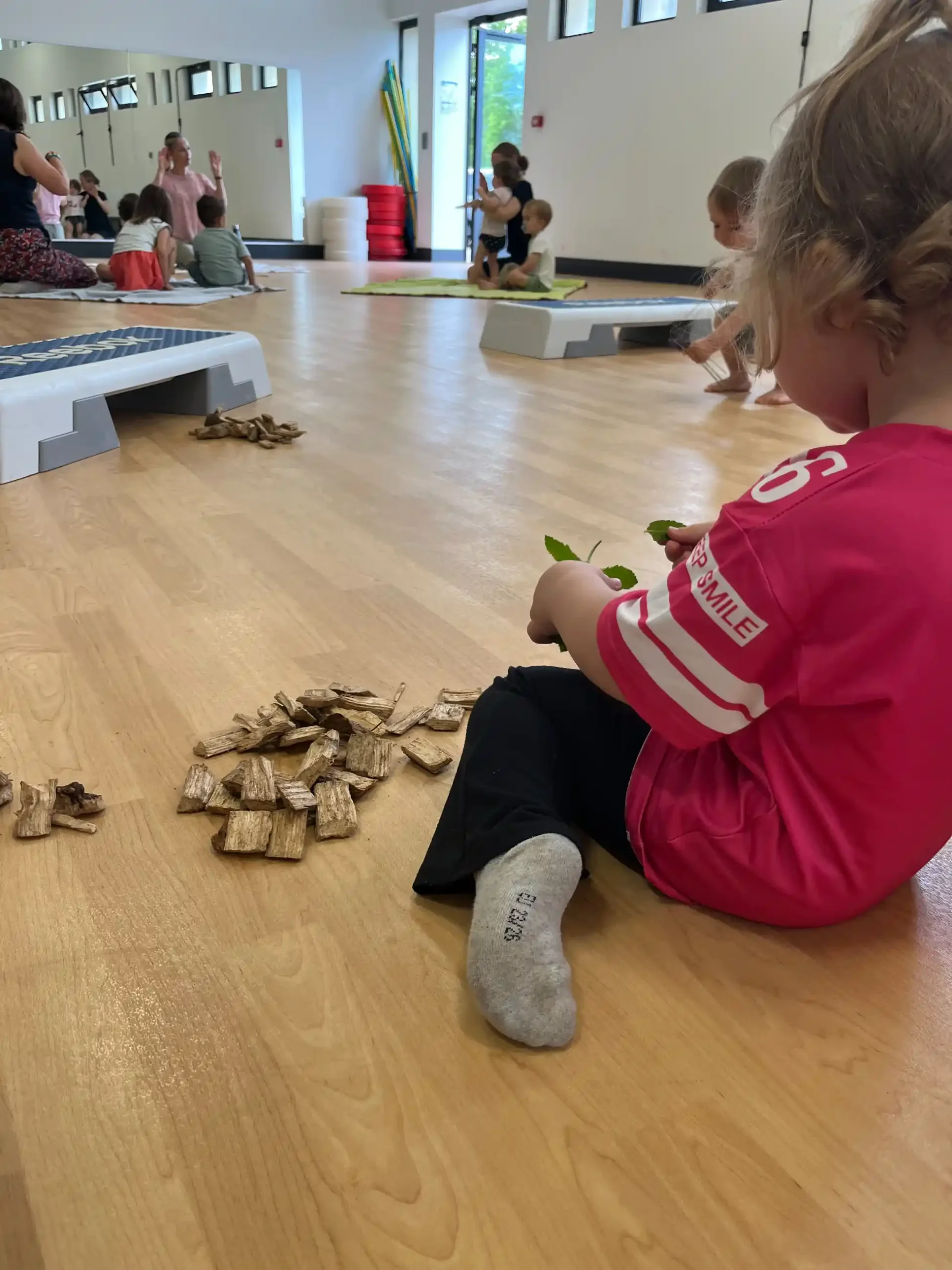 Jeune enfant jouant avec des pièces de bois dans une salle de motricité